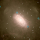 Bright galaxies (blue) and dim dwarf galaxies (white) orbiting a simulated galaxy’s center.
